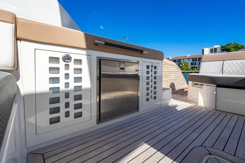 Slide: The Image of 2019 Sea Ray SLX 400 Outboard boat deck with seating and storage, under clear blue sky. - 51