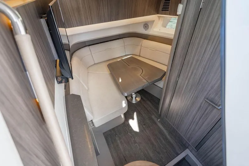 Slide: The Image of 2019 Sea Ray SLX 400 Outboard cabin interior with seating and table. - 53