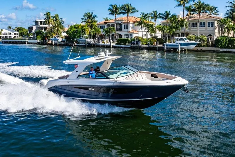Slide: The Image of 2019 Sea Ray SLX 400 Outboard cruising near luxury waterfront homes. - 8