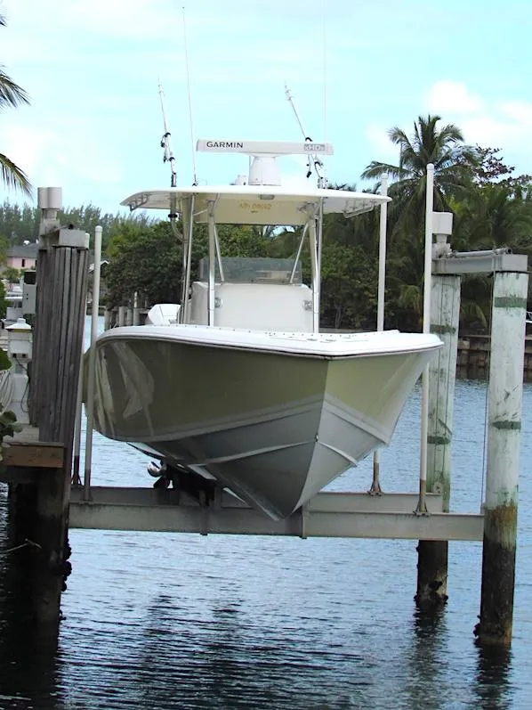 The Image of 2005 Venture 34 Open boat on lift, surrounded by water and palm trees. - 0