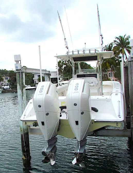 Slide: The Image of 2005 Venture 34 Open boat with dual outboard engines docked by the water. - 1