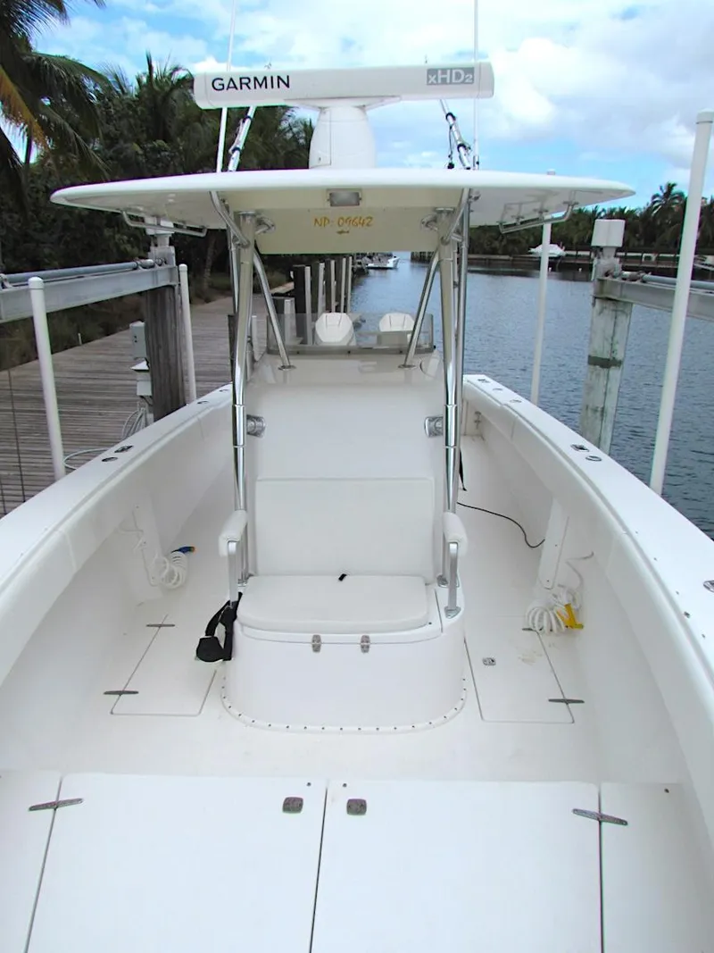 Slide: The Image of 2005 Venture 34 Open boat with Garmin equipment, docked by a serene waterway. - 11