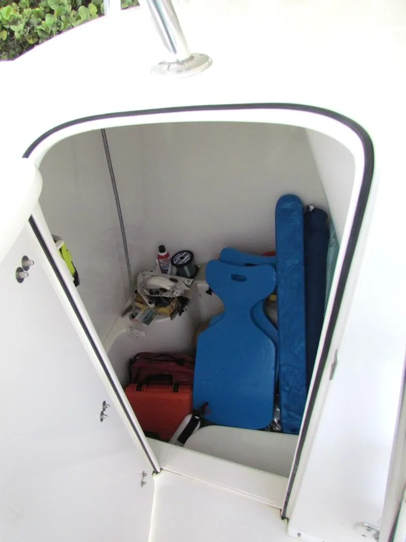 Slide: The Image of Storage compartment of 2005 Venture 34 Open boat with various items inside. - 12