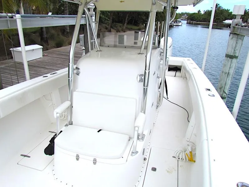 Slide: The Image of 2005 Venture 34 Open boat, spacious deck, white seating, docked by a serene waterway. - 13