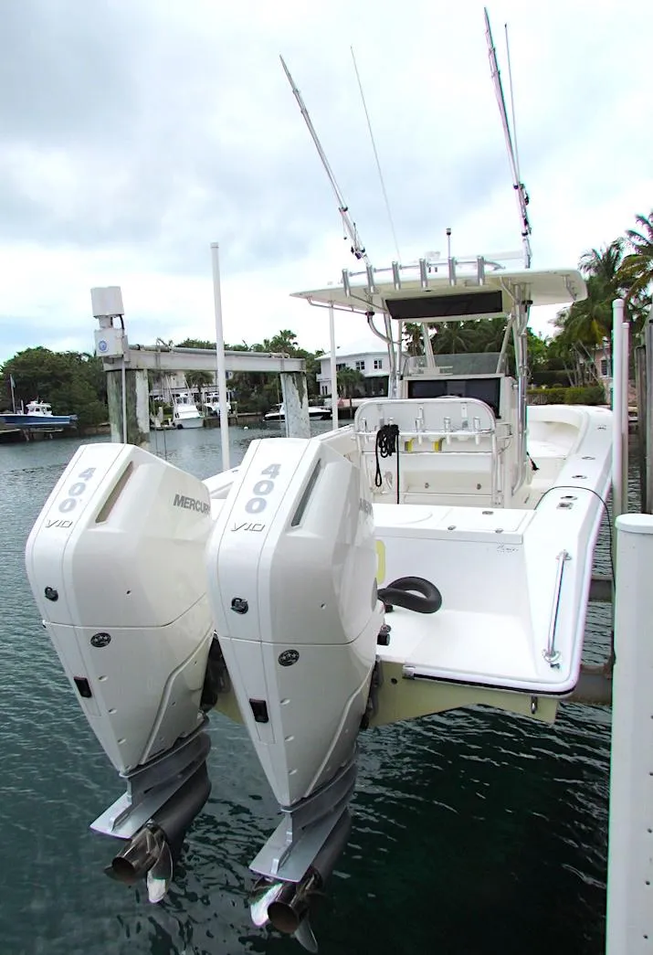 Slide: The Image of 2005 Venture 34 Open boat with twin Mercury engines docked in a marina. - 2