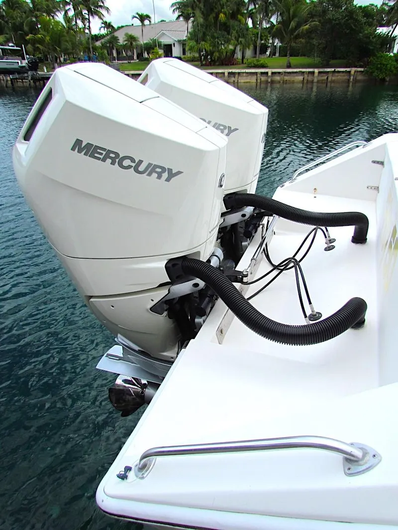 Slide: The Image of 2005 Venture 34 Open boat with dual Mercury outboard engines, docked by the water. - 3