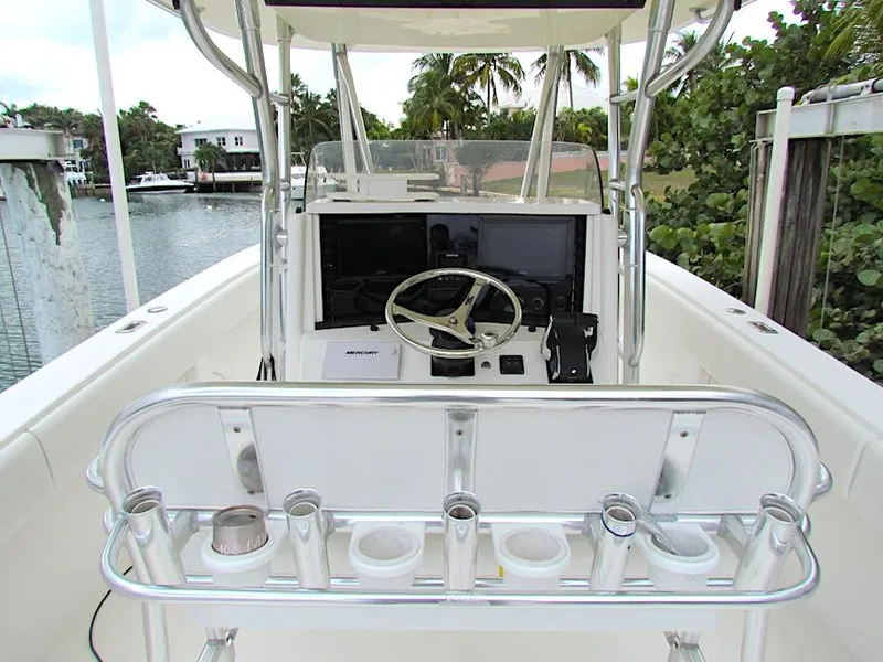 Slide: The Image of 2005 Venture 34 Open boat helm with steering wheel and rod holders, docked by a canal. - 4