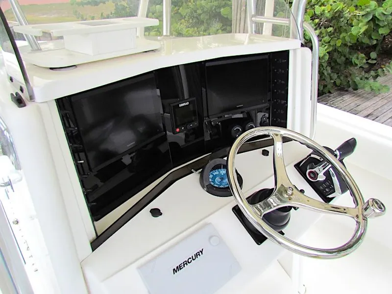 Slide: The Image of 2005 Venture 34 Open boat dashboard with steering wheel and Mercury controls. - 6