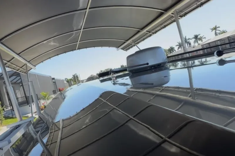 Slide: The Image of 2022 Nor-Tech 390 Sport boat under a canopy, reflecting clear blue sky and palm trees. - 10