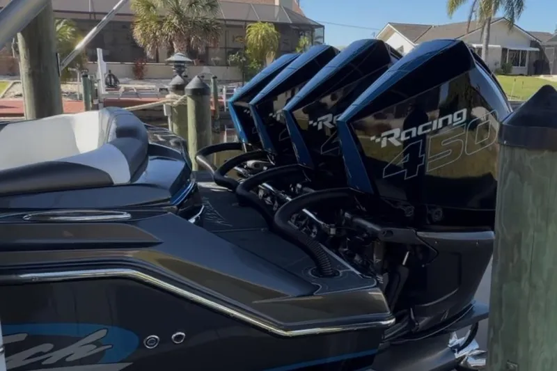 Slide: The Image of 2022 Nor-Tech 390 Sport with triple Racing 450 engines docked by waterfront homes. - 11
