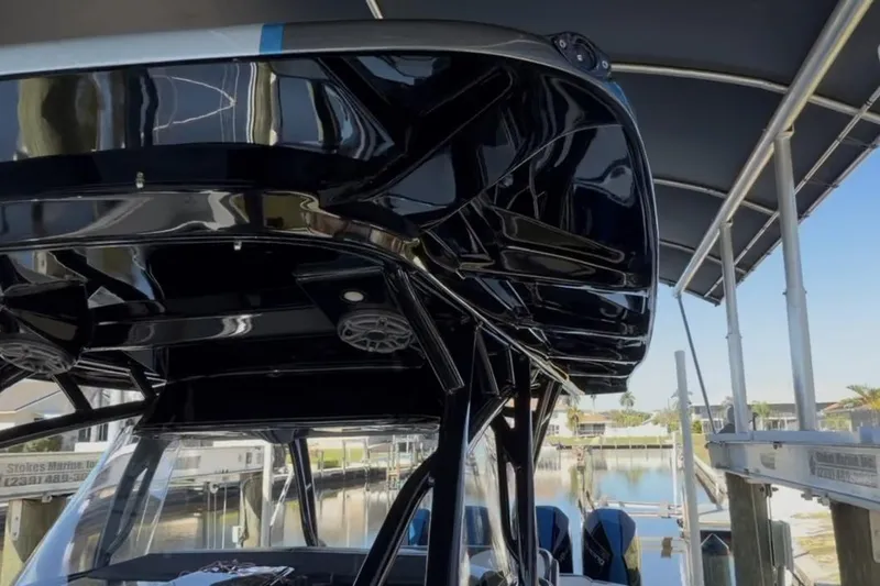 Slide: The Image of 2022 Nor-Tech 390 Sport boat with sleek black design, docked under a canopy. - 14