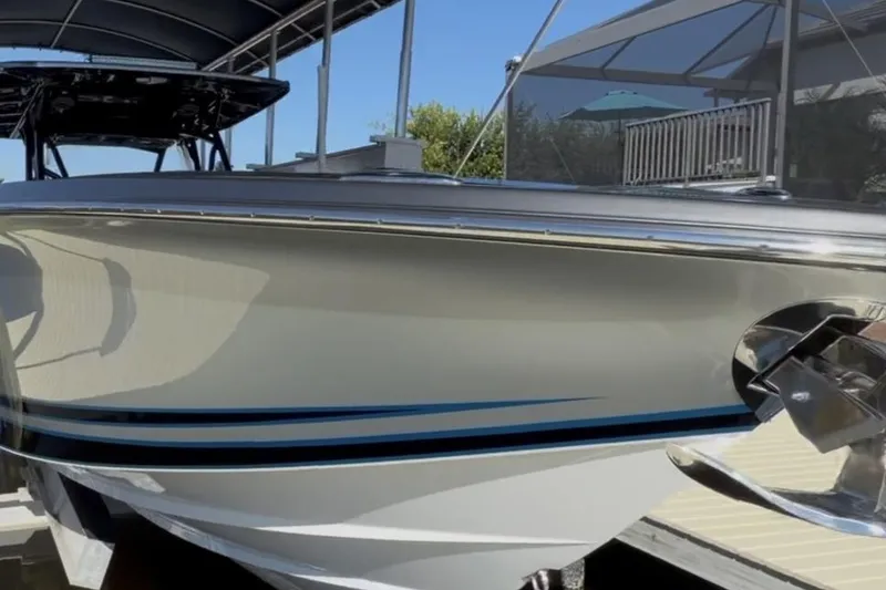 Slide: The Image of 2022 Nor-Tech 390 Sport boat, sleek design, docked under a canopy. - 19