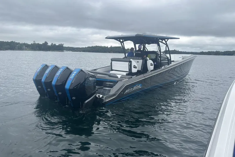 Slide: The Image of 2022 Nor-Tech 390 Sport boat with quad engines on a calm lake. - 2