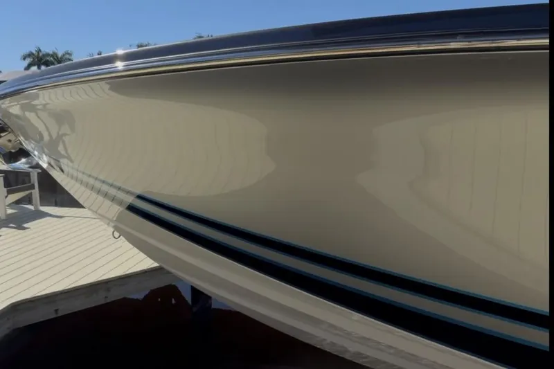 Slide: The Image of 2022 Nor-Tech 390 Sport boat hull reflecting sunlight at a dock. - 21