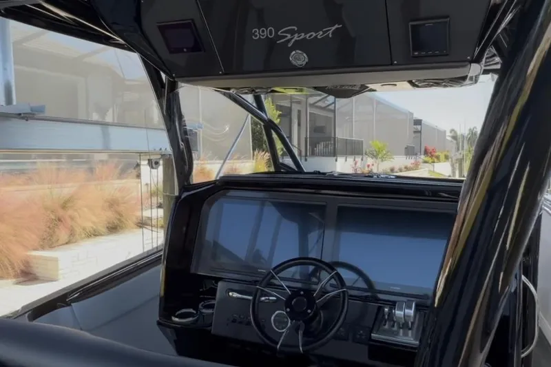 Slide: The Image of 2022 Nor-Tech 390 Sport boat dashboard with steering wheel and modern controls. - 3