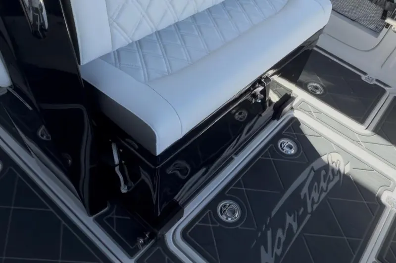 Slide: The Image of 2022 Nor-Tech 390 Sport boat interior with white quilted seating and branded flooring. - 4