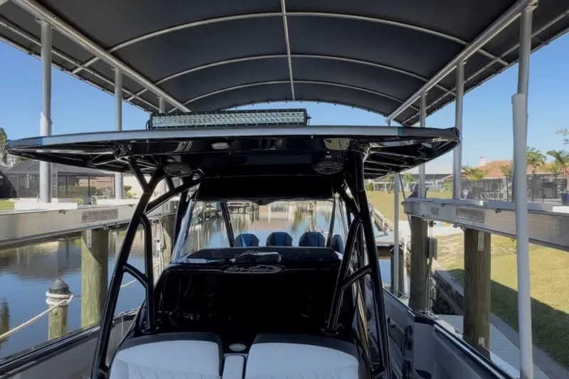 Slide: The Image of 2022 Nor-Tech 390 Sport boat docked under a covered marina. - 5