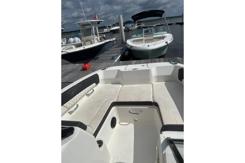 Slide: The Image of 2023 Bayliner DX 2200 boat interior at dock, featuring spacious seating and sleek design. - 5