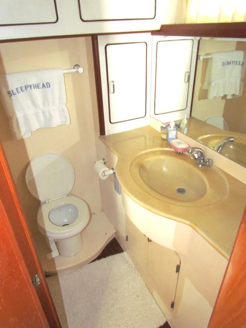 Slide: The Image of Compact bathroom in a 1997 Hyatt 55 yacht with sink, toilet, and mirror. - 24