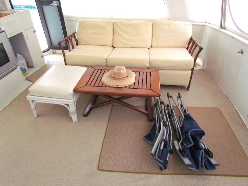 Slide: The Image of Cozy yacht interior with beige sofa, wooden table, and folded chairs, Hyatt 55, 1997 model. - 9