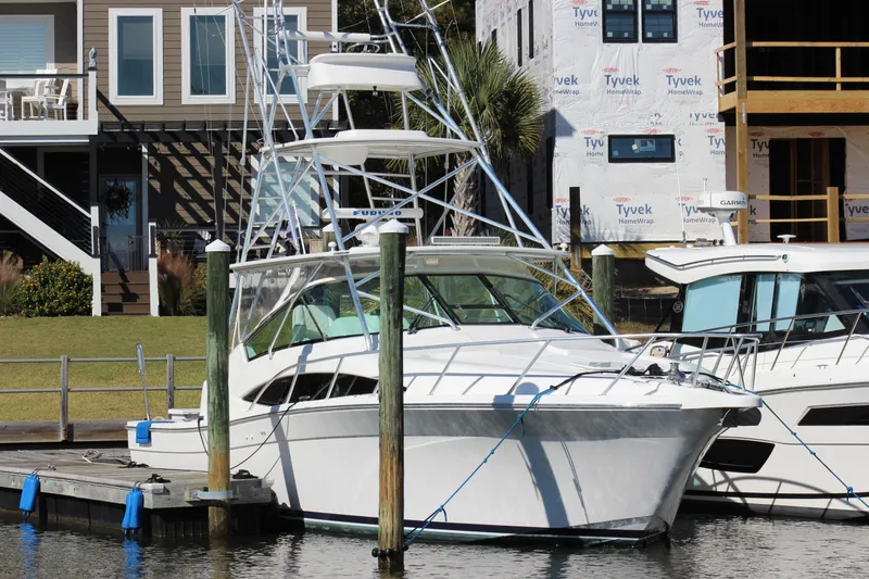 The Image of 2008 Bertram 360 yacht docked near waterfront homes. - 0