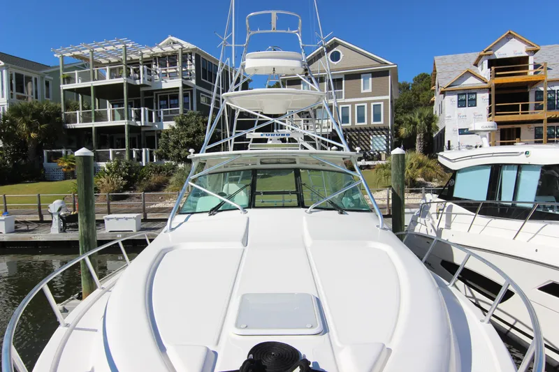 Slide: The Image of 2008 Bertram 360 yacht docked at marina, surrounded by modern waterfront homes. - 11