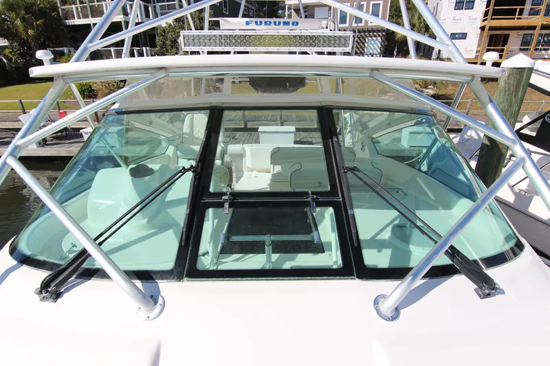 Slide: The Image of 2008 Bertram 360 boat cockpit with windshield and metal frame, docked at marina. - 12