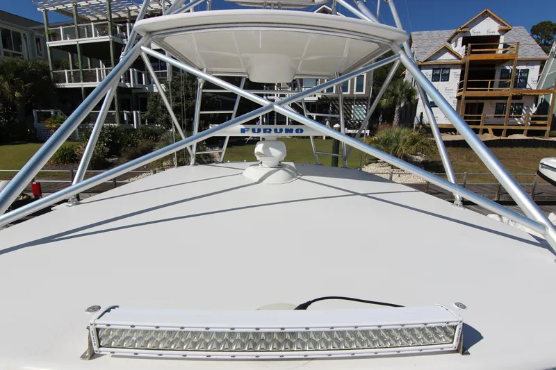 Slide: The Image of 2008 Bertram 360 boat with radar and light bar, docked near modern homes. - 13