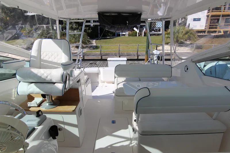 Slide: The Image of 2008 Bertram 360 yacht interior with white seating and helm, dockside view. - 27