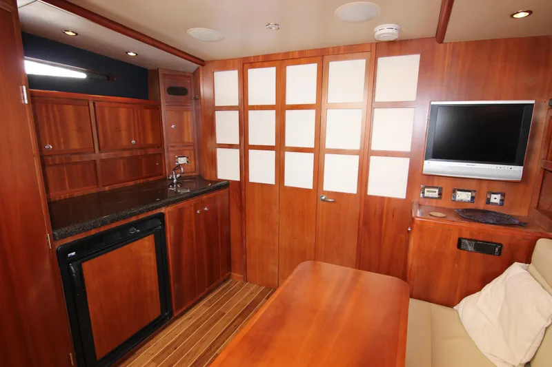 Slide: The Image of Luxurious 2008 Bertram 360 yacht interior with wood cabinetry, kitchenette, and TV. - 45