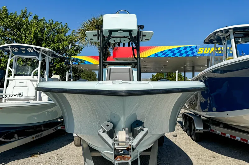 Slide: The Image of 2019 Yellowfin 26 Hybrid boat displayed at a dealership, surrounded by other boats. - 1