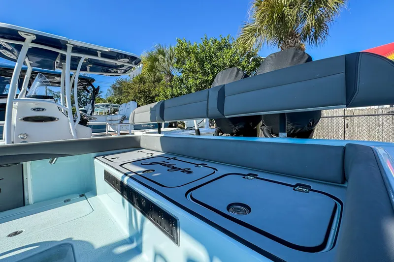 Slide: The Image of 2019 Yellowfin 26 Hybrid boat interior with seating and storage, under clear blue sky. - 12