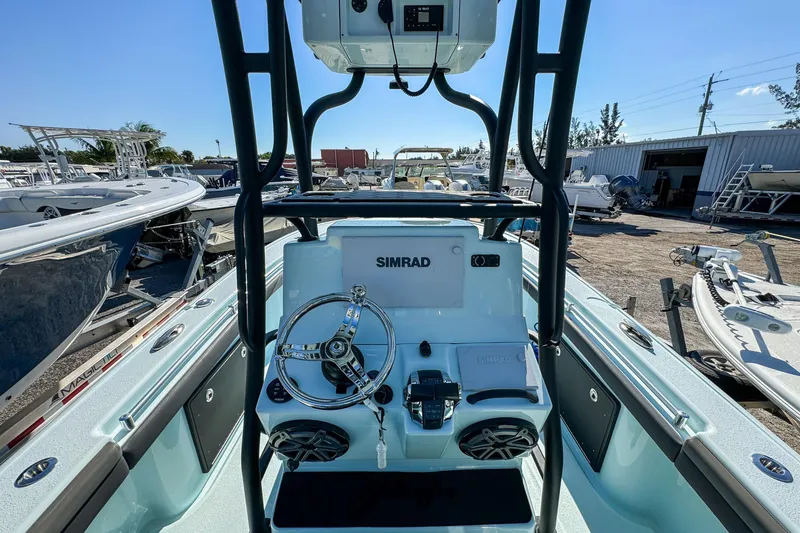 Slide: The Image of 2019 Yellowfin 26 Hybrid boat dashboard with Simrad electronics in a marina setting. - 19