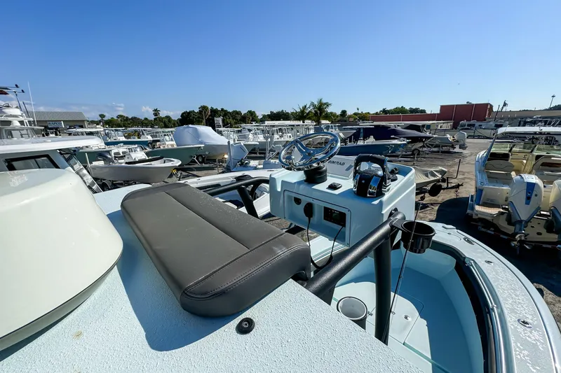 Slide: The Image of 2019 Yellowfin 26 Hybrid boat with steering console, docked among other boats. - 24