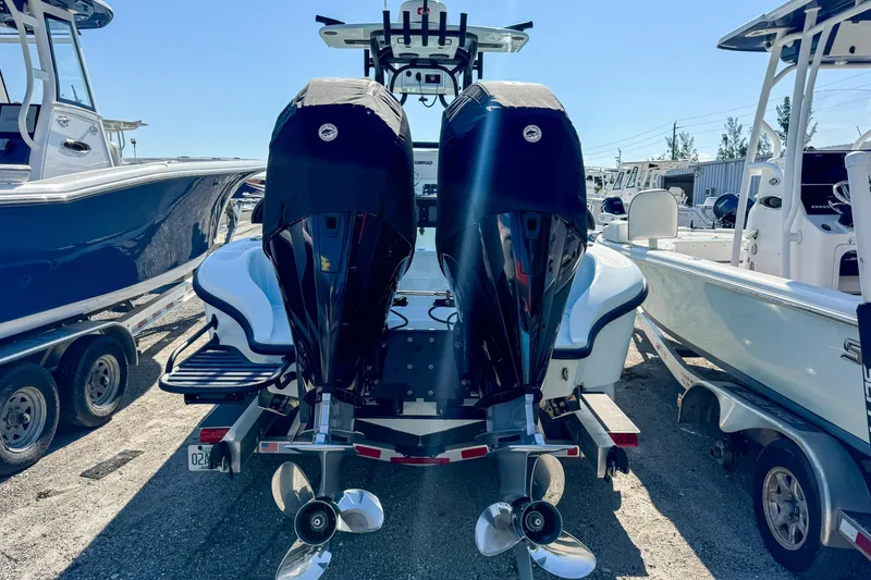 Slide: The Image of 2019 Yellowfin 26 Hybrid boat with dual outboard motors, parked on a trailer. - 4