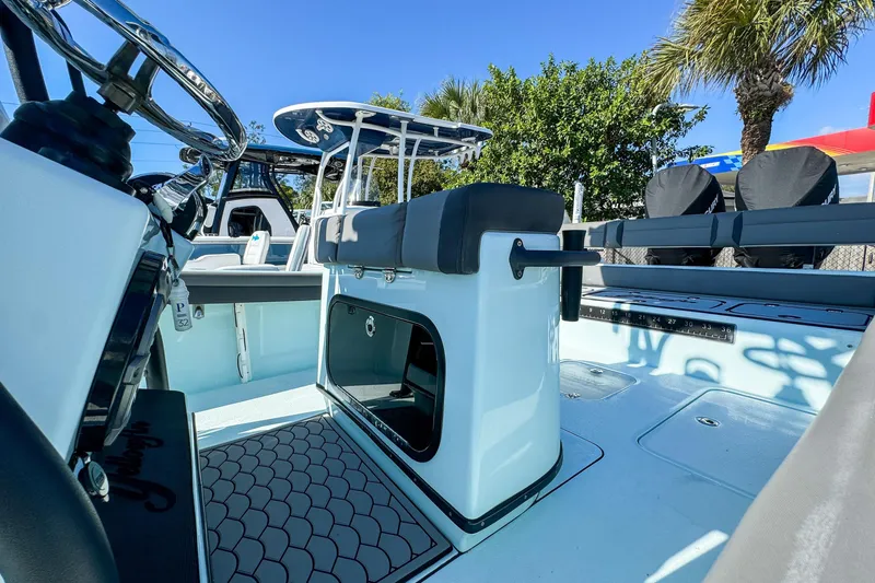Slide: The Image of 2019 Yellowfin 26 Hybrid boat interior with seating and steering wheel, under clear blue sky. - 7