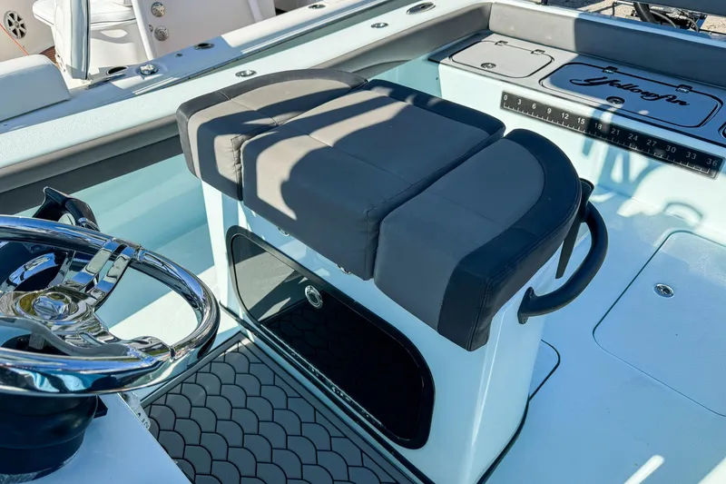 Slide: The Image of 2019 Yellowfin 26 Hybrid boat interior with steering wheel and cushioned seating. - 8