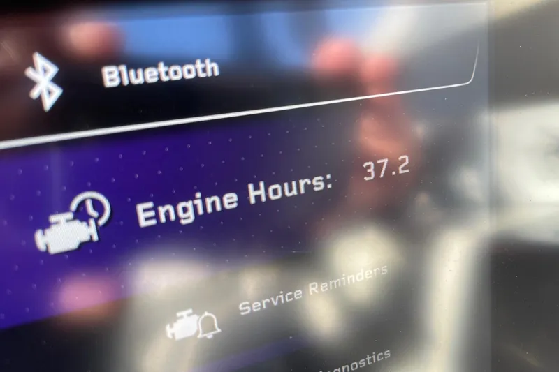 Slide: The Image of Display screen showing Bluetooth connectivity and engine hours at 37.2 on 2025 Nautique G25 Paragon. - 13