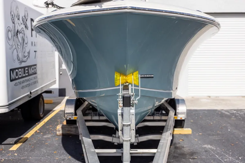 Slide: The Image of 2018 Sailfish 241 CC boat on trailer, front view, parked outdoors. - 11