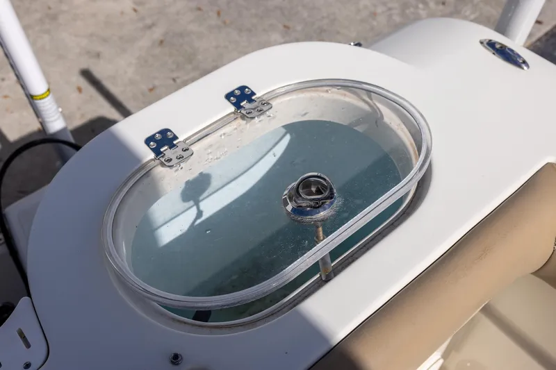 Slide: The Image of Livewell on 2018 Sailfish 241 CC boat, featuring a clear lid and secure hinges. - 14