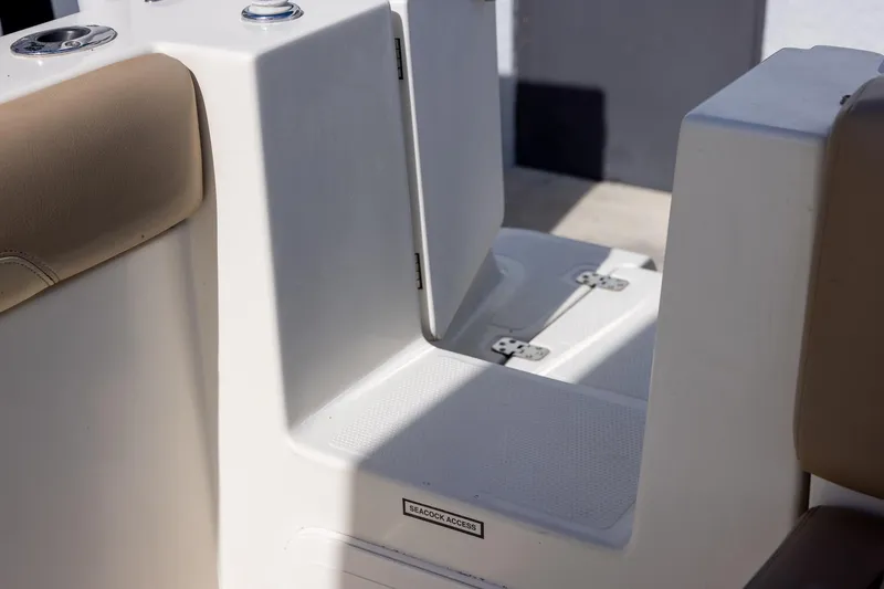 Slide: The Image of 2018 Sailfish 241 CC boat interior with beige seating and seacock access panel. - 25