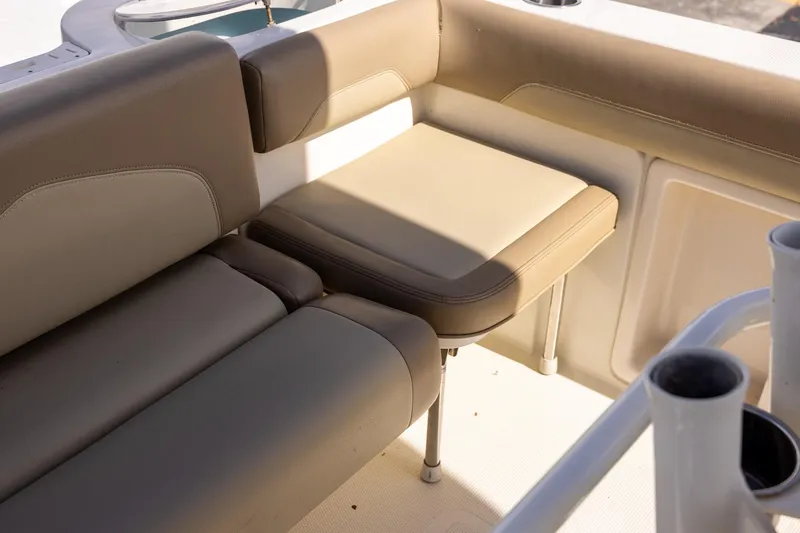 Slide: The Image of 2018 Sailfish 241 CC boat interior seating with beige cushions and rod holders. - 29