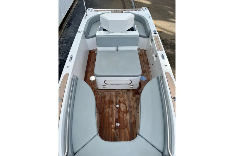 Slide: The Image of 2021 Novurania Chase 19 boat interior with gray seating and wooden deck. - 2