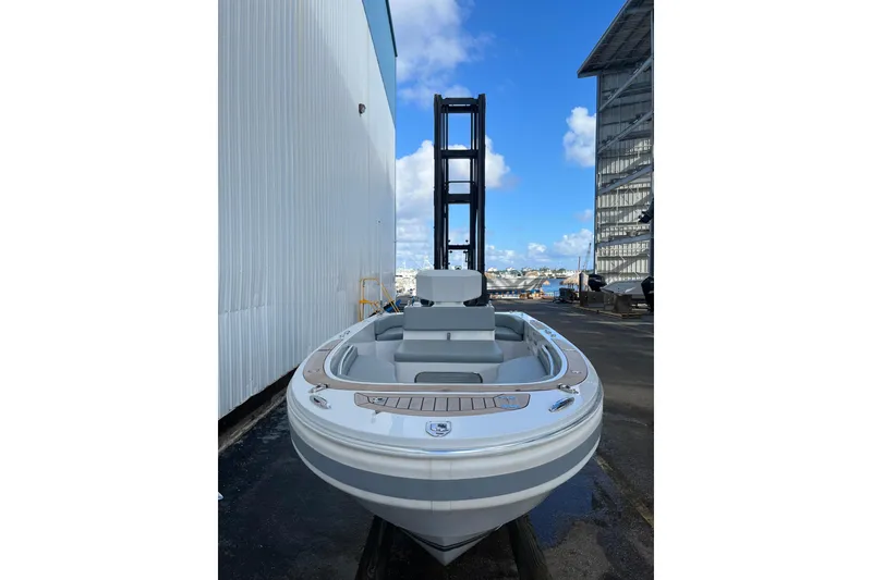 Slide: The Image of 2021 Novurania Chase 19 boat docked near industrial buildings under a clear blue sky. - 4