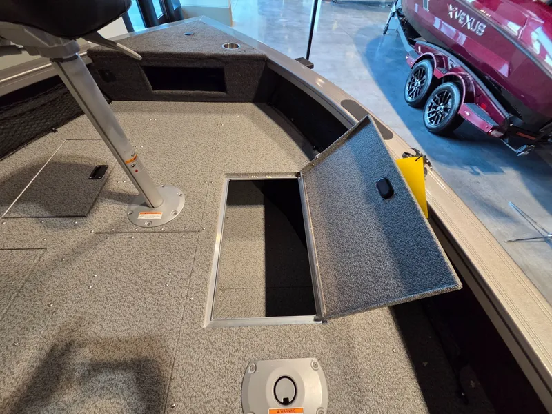 Slide: The Image of Interior of Crestliner 1850 Pro Tiller 2026 with open storage compartment. - 10