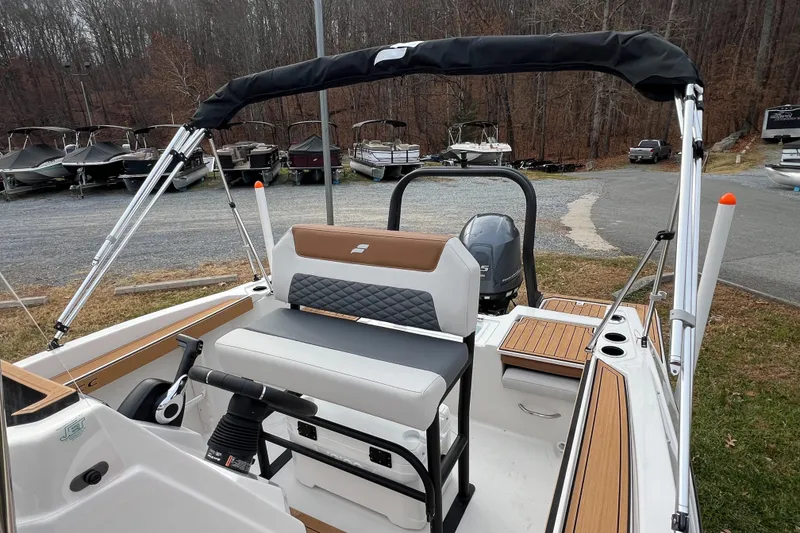 Slide: The Image of 2026 Starcraft SVX 191 OB CC boat with seating and outboard motor, parked outdoors. - 10