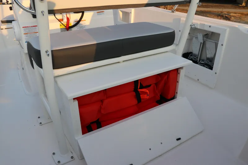 Slide: The Image of 2025 Robalo R160 Center Console boat with storage compartment and life jackets. - 16