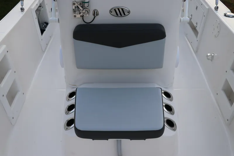 Slide: The Image of 2025 Robalo R160 Center Console boat interior with cushioned seating and rod holders. - 29