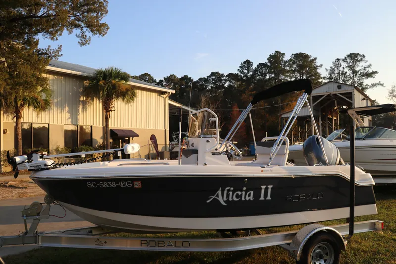 Slide: The Image of 2025 Robalo R160 Center Console boat on trailer, parked outdoors. - 4