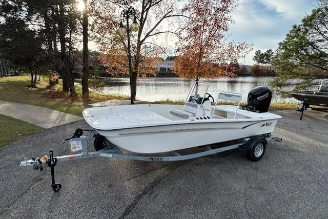 The Image of 2025 Mako Pro Skiff 17 CC boat on trailer by a scenic lake. - 0